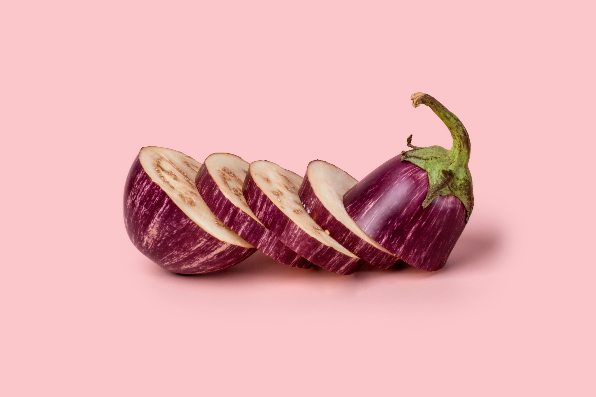 sliced eggplant on a pink background