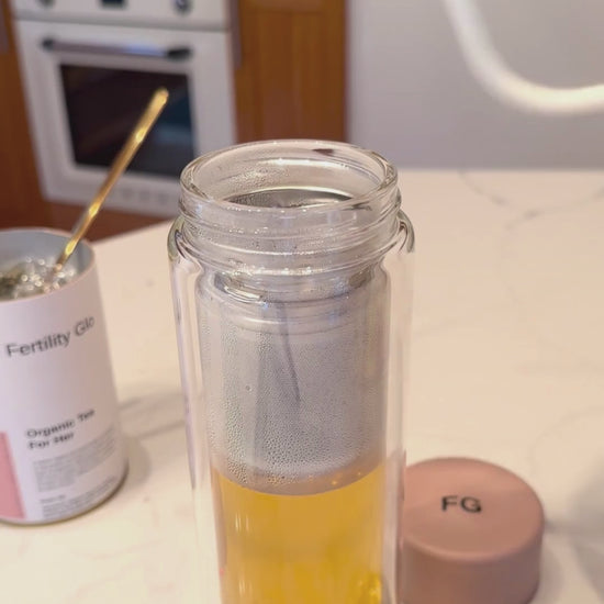 pouring tea in glass bottle with infuser